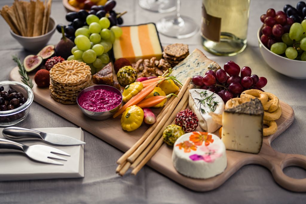 charcuterie board with cheeses, fruits and crackers