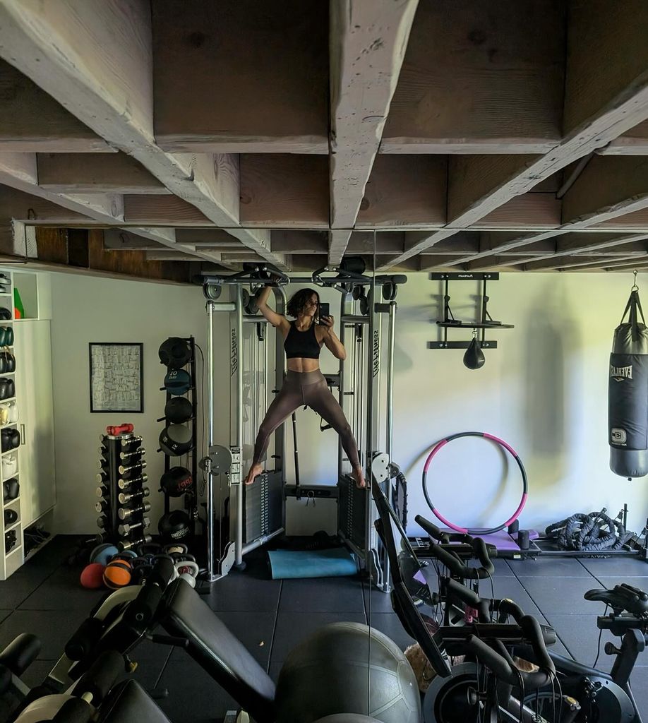 photo of halle berry in home gym standing on aparatus