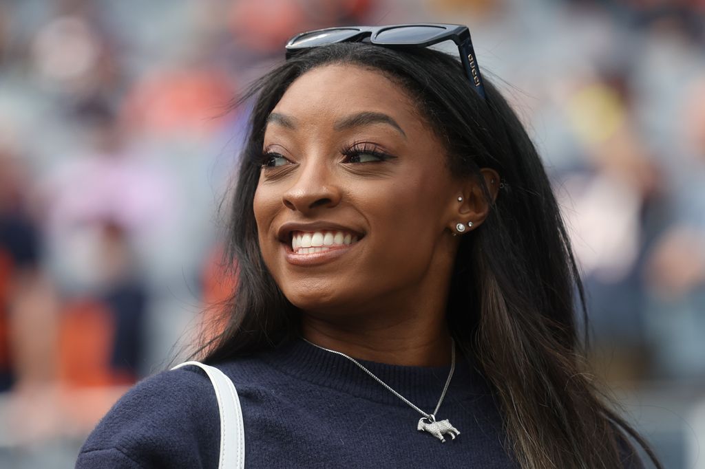 Gymnast Simone Biles stands on the sideline before the football game between the Los Angeles Rams and the Chicago Bears at Solider Field on September 29, 2024 in Chicago, Illinois.