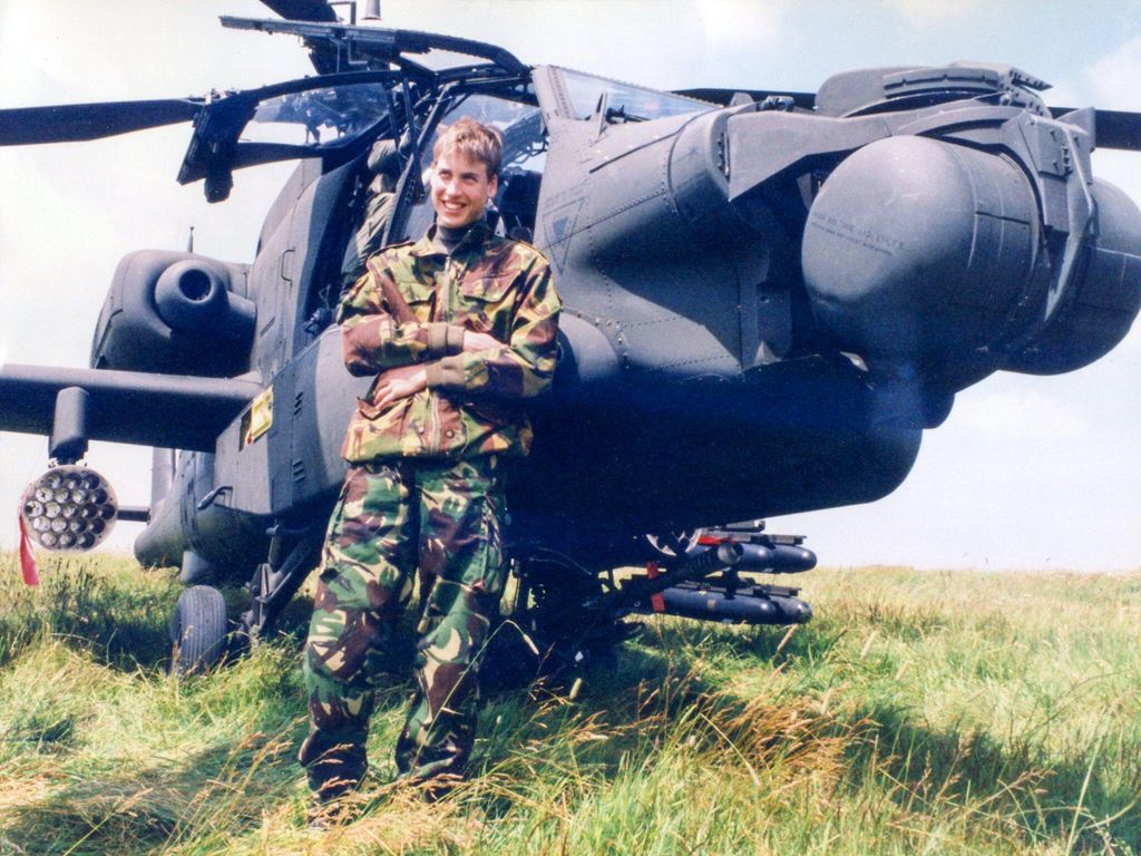 Prince William leaning up against a helicopter in 1999