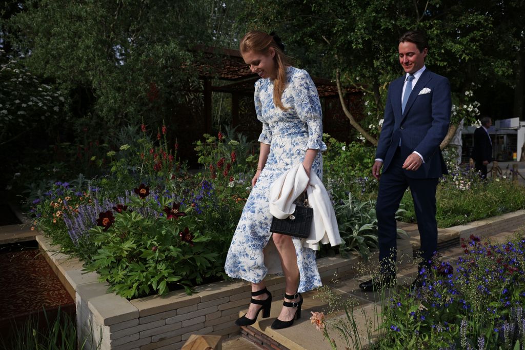 Princess Beatrice walking down steps in a blue and white midi dress