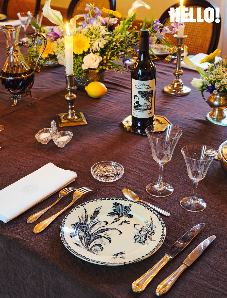 La table à manger décorée de sprays de fleurs colorés, de canles et d'assiettes avec un motif floral dans le château Toulouse-Lautrec