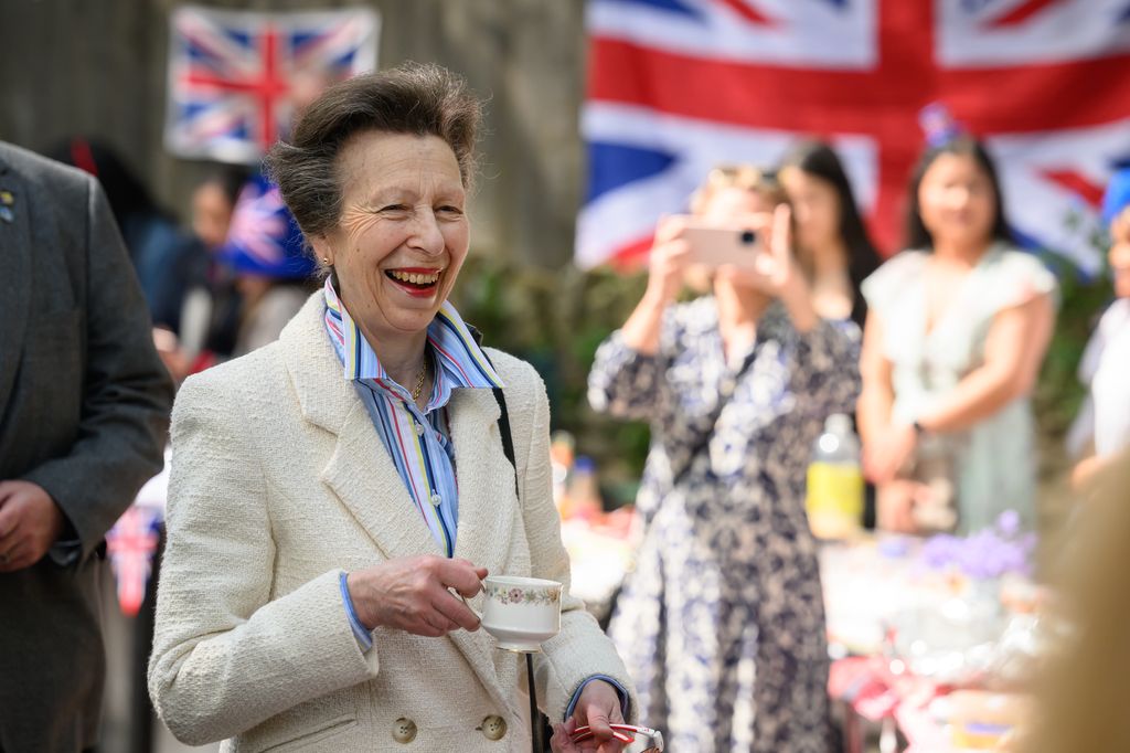 Princess Anne holds a cup of tea at a street party