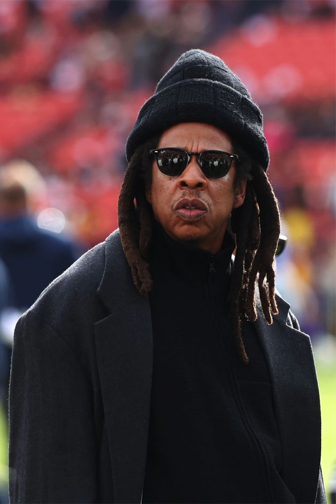 Jay-Z in a black outfit at a football match