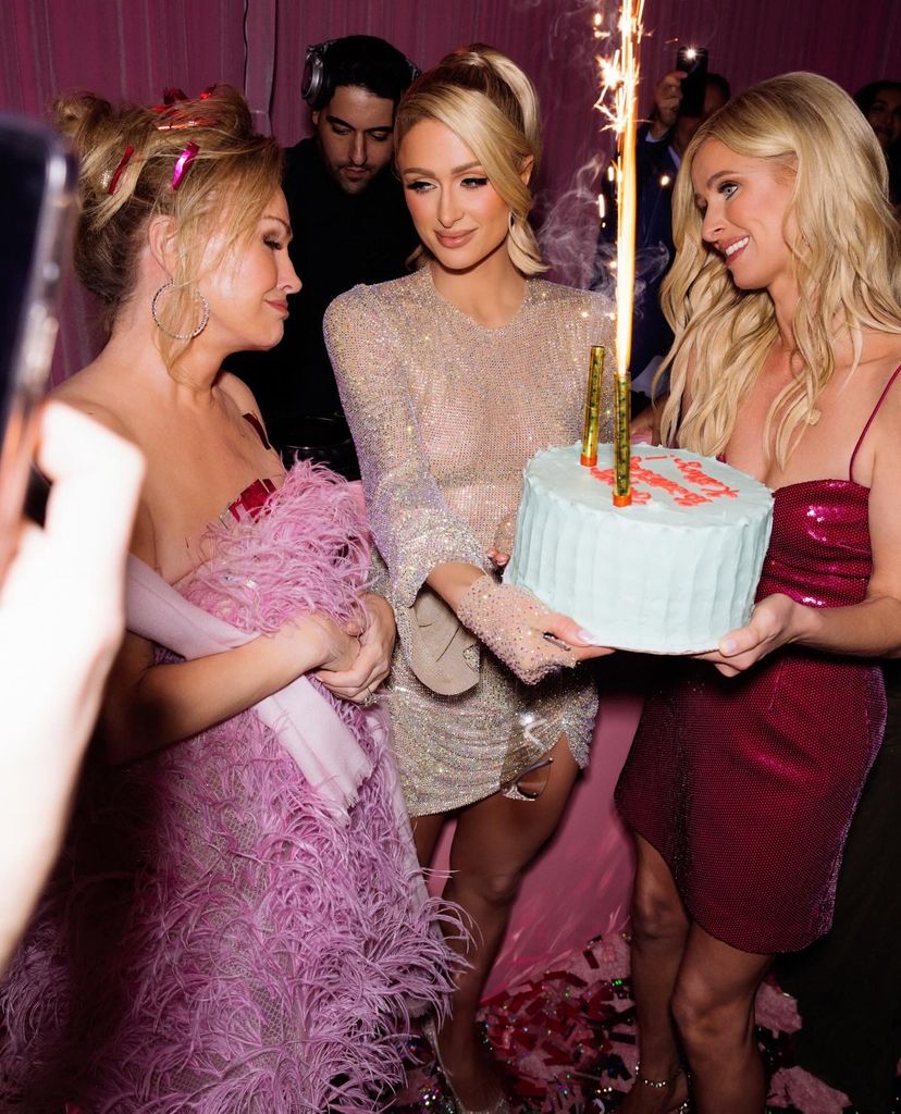 Kathy Hilton is presented with a cake by daughters Paris and Nicky