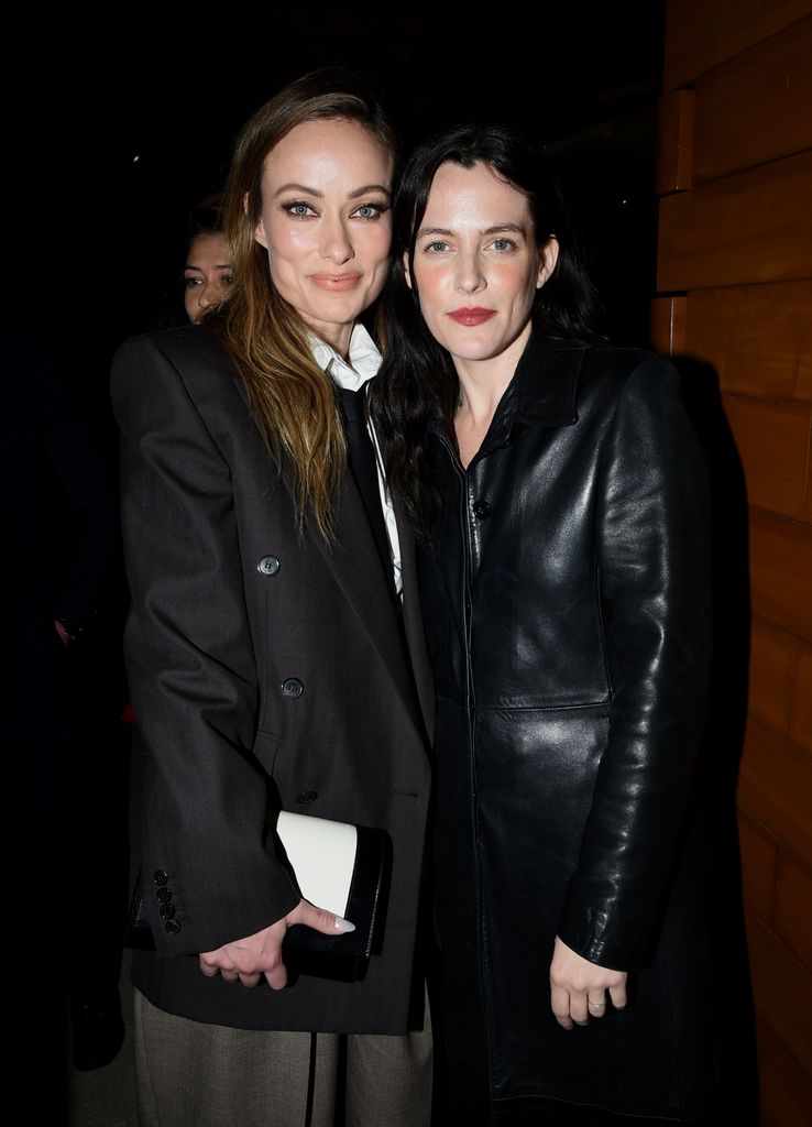 olivia wilde posing next to riley keough