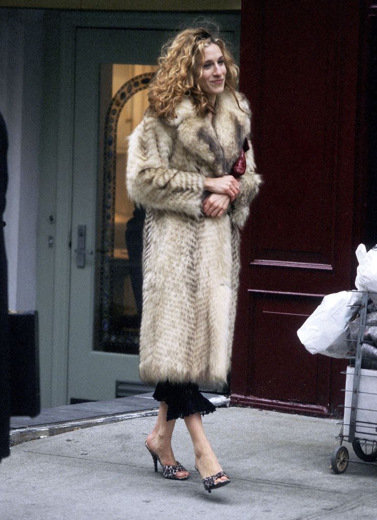 Carrie Bradshaw wearing a fur coat and leopard mules 