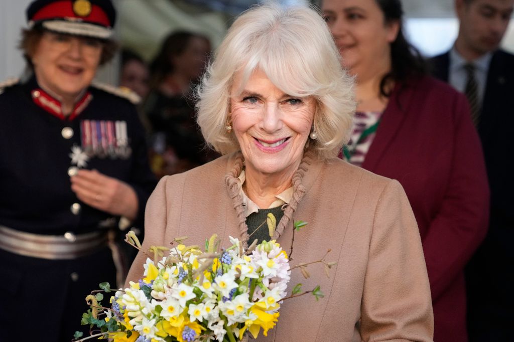 Queen Camilla smiling holding flowers