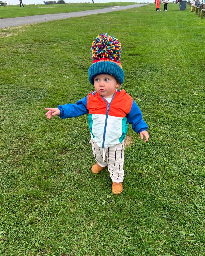 little boy in colouful pom-pom hat 