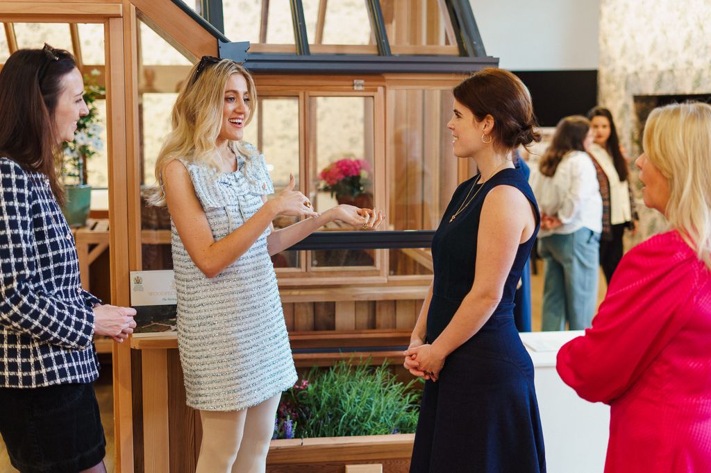 Princess Eugenie listens to woman talking