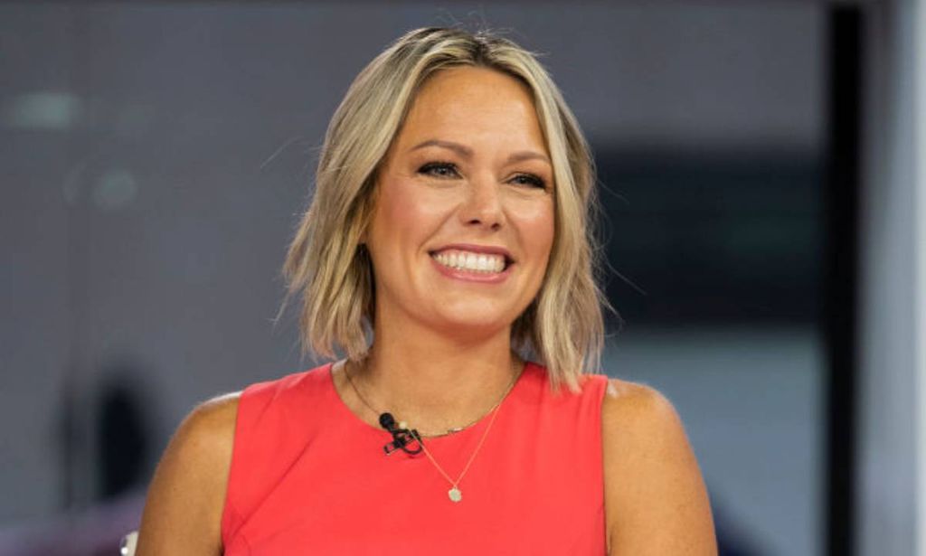 Dylan Dreyer smiles on the set of Today wearing an orange outfit 