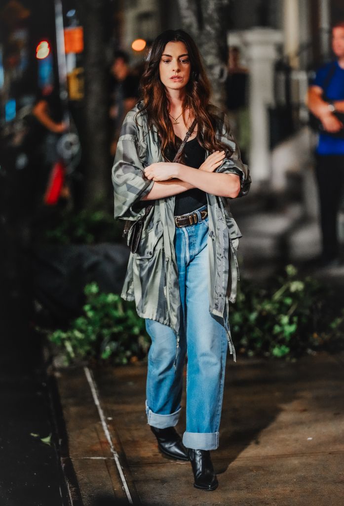 Anne Hathaway wearing a Silk Striped Utility Jacket in Green from Dries Van Noten. Stella McCartney Ryder Flap Crossbody Bag in Espresso, Favorite Daughter The Jordan Studded Belt and Levi's Low Pro Lightweight Women’s Jeans