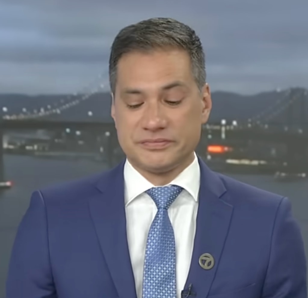 Reggie Aqui in navy suit crying