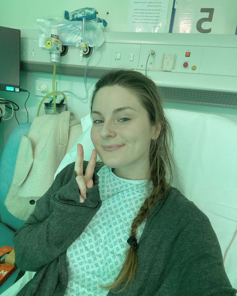 Young woman making the peace sign from a hospital bed