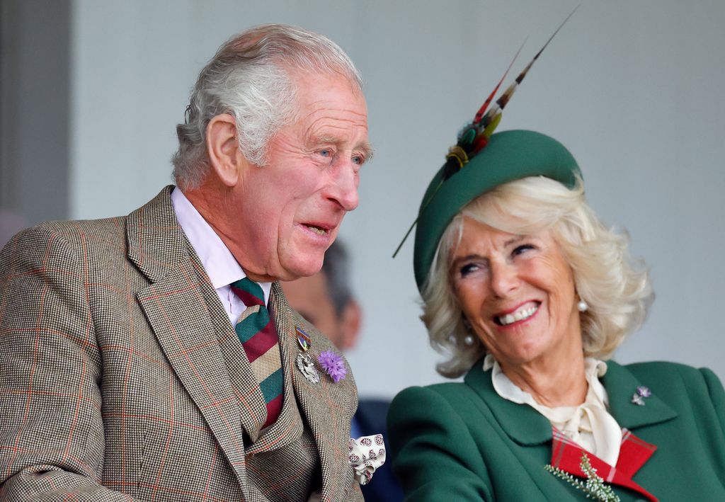 King Charles wears tweed suit and Queen Camilla wears emerald green suit with fascinator