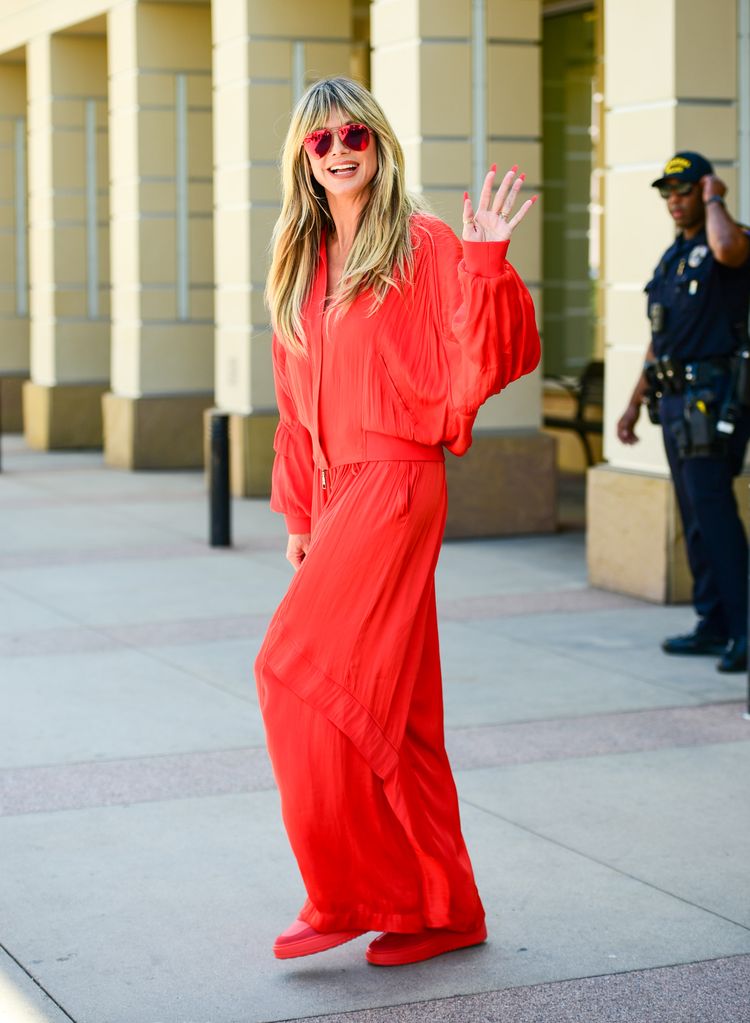 Heidi waving in a red tracksuit