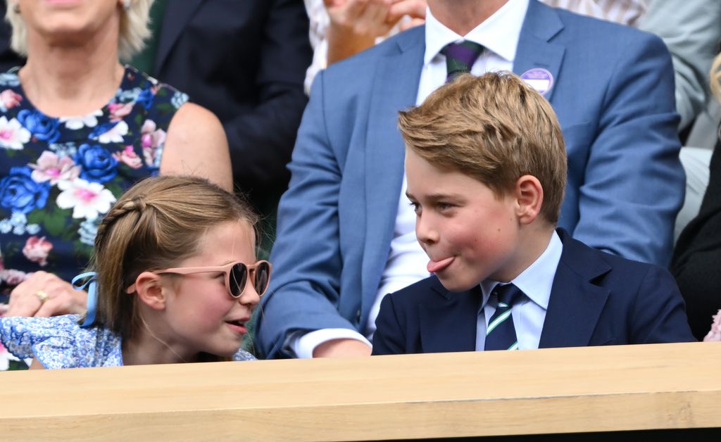 Princess Charlotte with Prince George, who is sticking his tongue out