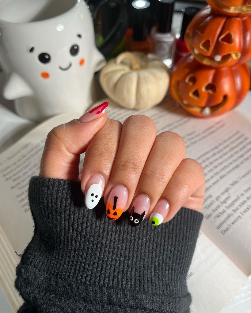 These nails feature an adorable lineup of Halloween icons: a ghost, jack-o’-lantern, black cat, and a green-eyed monster.