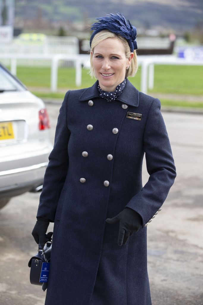 Zara in navy coat with a fascinator