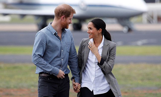 Prince Harry and Meghan Markle smiling at each other during their royal tour of Australia and New Zealand