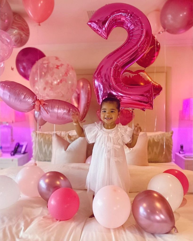True surrounded by pink balloons