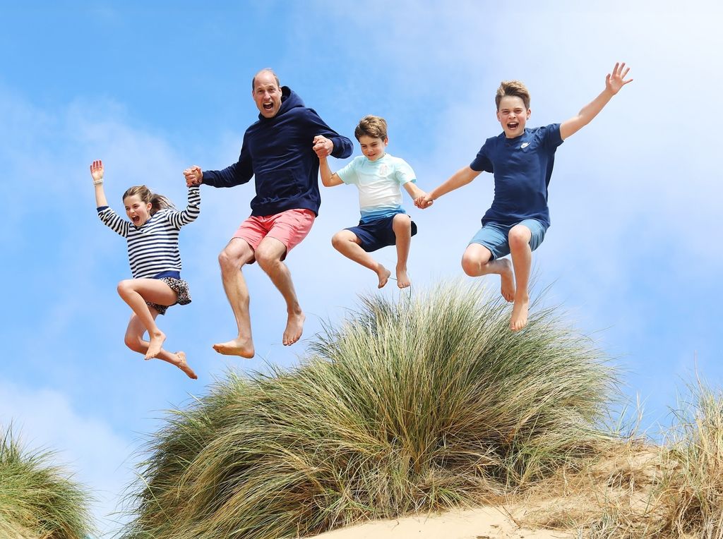 Prince William jumping with George, Charlotte and Louis on Norfolk beach