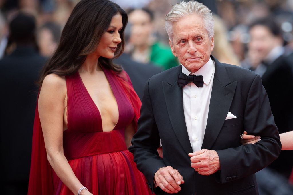 Catherine Zeta-Jones in a red dress with her husband Michael Douglas on the red carpet
