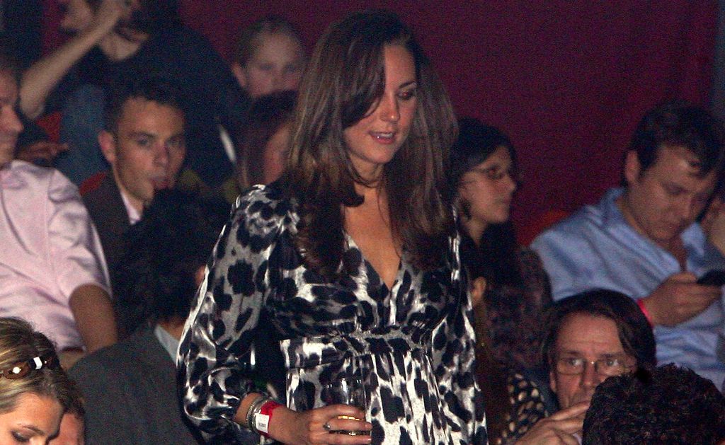 Kate Middleton in a leopard print dress with a drink in her hand