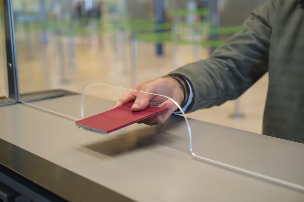 Passenger giving passport at airport check-in counter
