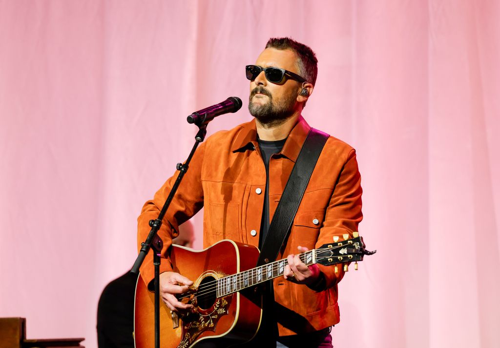 Eric Church sur scène portant des lunettes de soleil jouant de la guitare