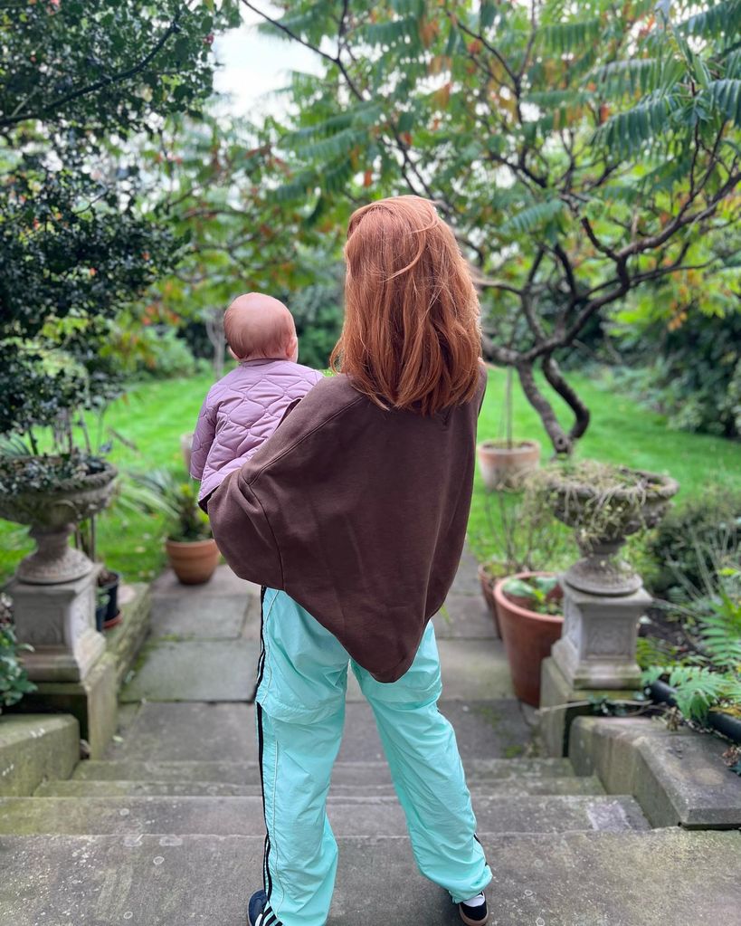 stacey dooley holding baby on steps 