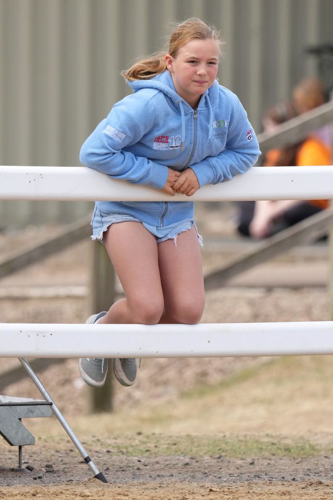 Mia Tindall leaning on a gate in casual clothes 