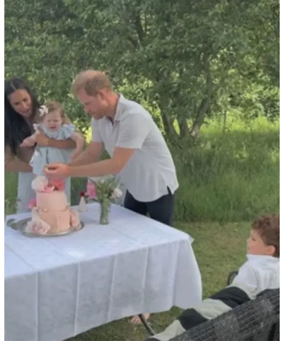 Prince Harry, Meghan Markle, Prince Archie watching Princess Lili blow out her candles