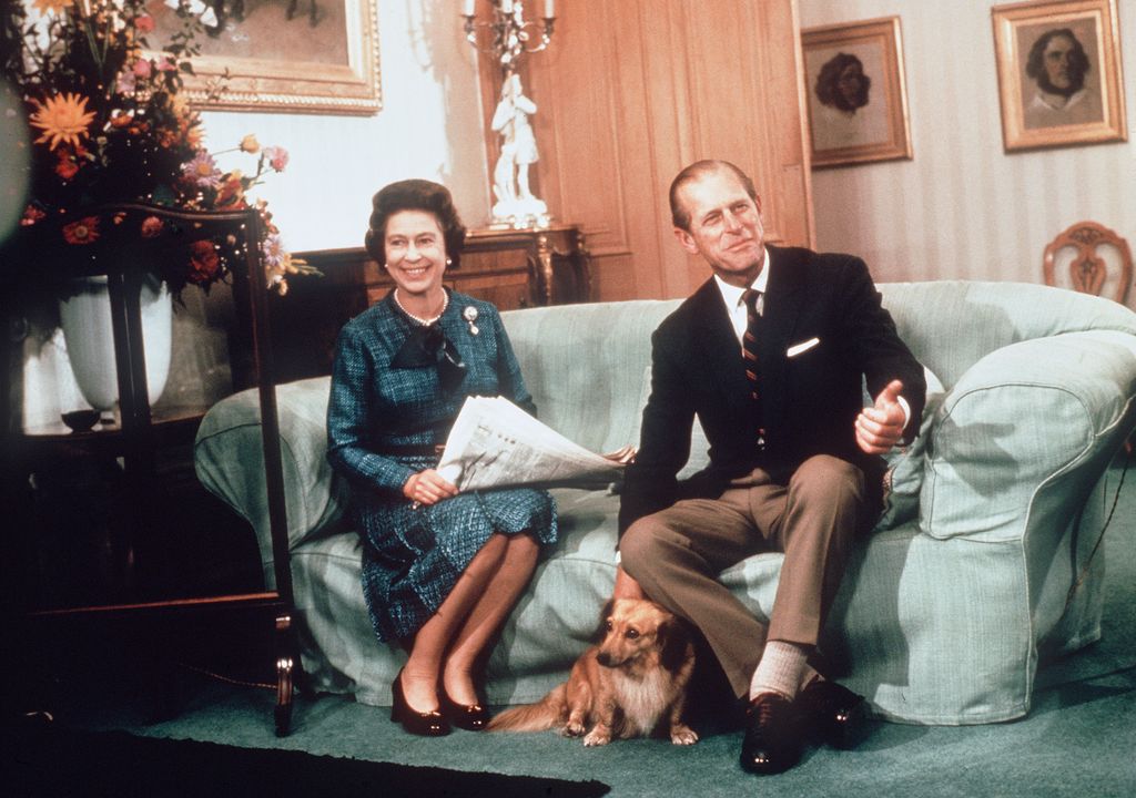 Queen Elizabeth ll and Prince Phillip the Duke of Edinburgh relaxing with their corgis and newspapers at Balmoral in 1975