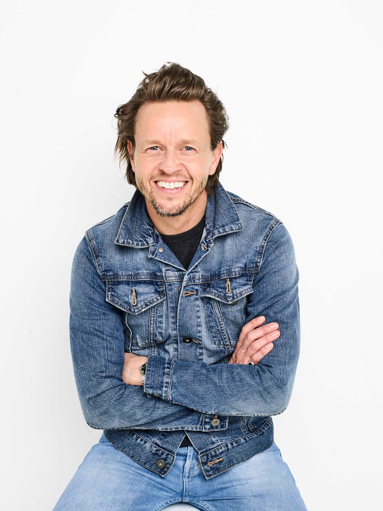 Man sitting in a white room wearing a denim jacket