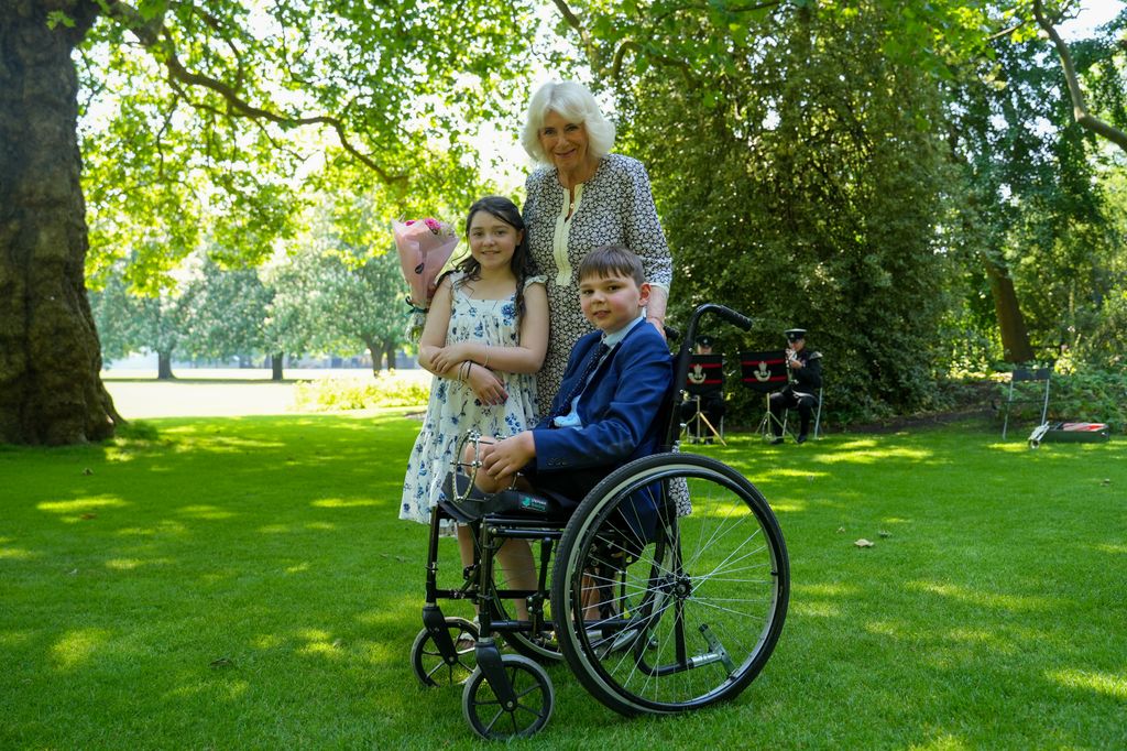 Queen Camilla with a young girl and a young boy in a wheelchair