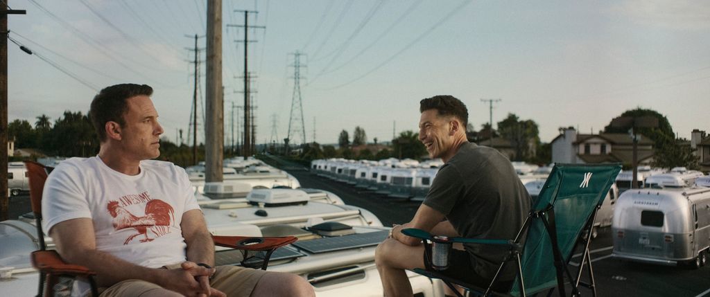 two men sitting in deck chairs on harbour