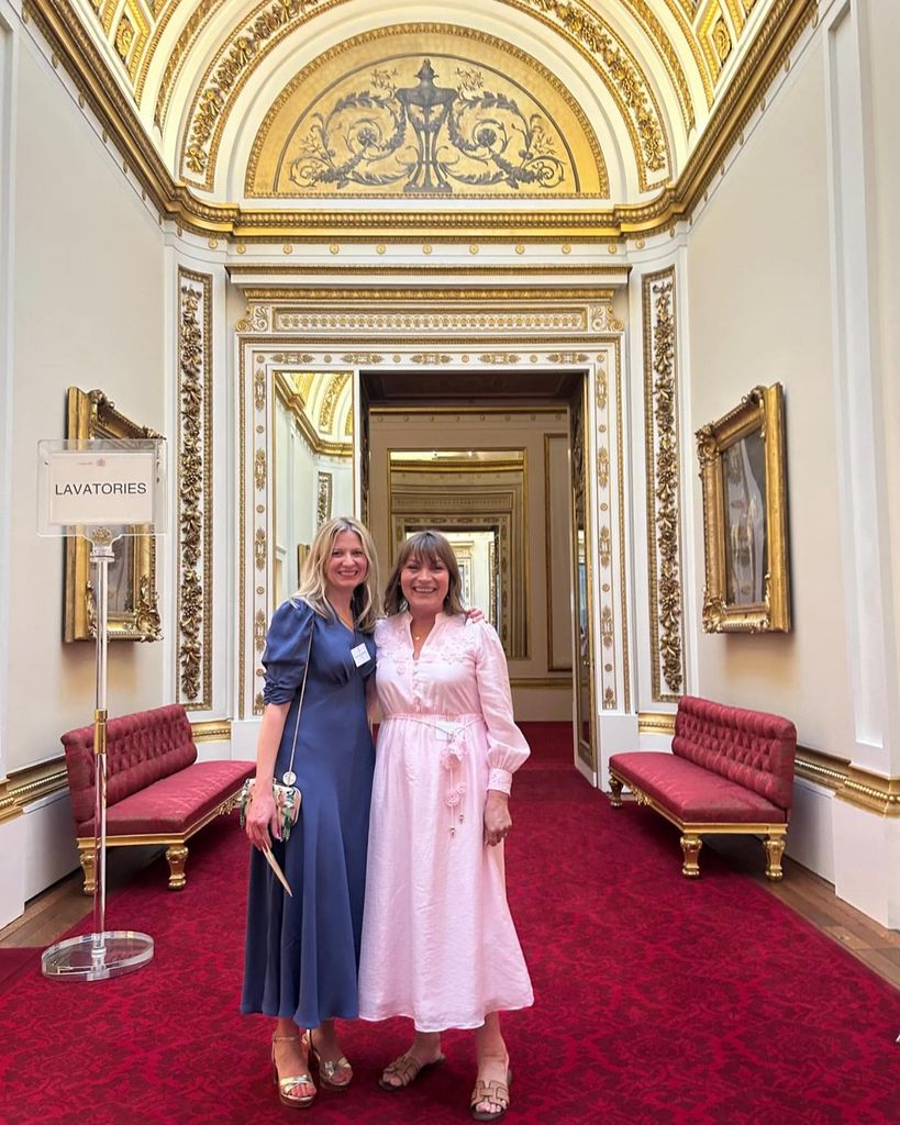 Lorraine Kelly wearing pink dress posing inside Buckingham Palace