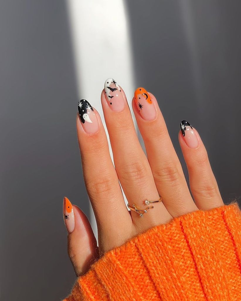 Black and orange combine with tiny stars, bats, and a sneaky ghost for a classic Halloween manicure.