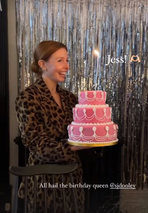 Stacey Dooley carrying a pink birthday cake