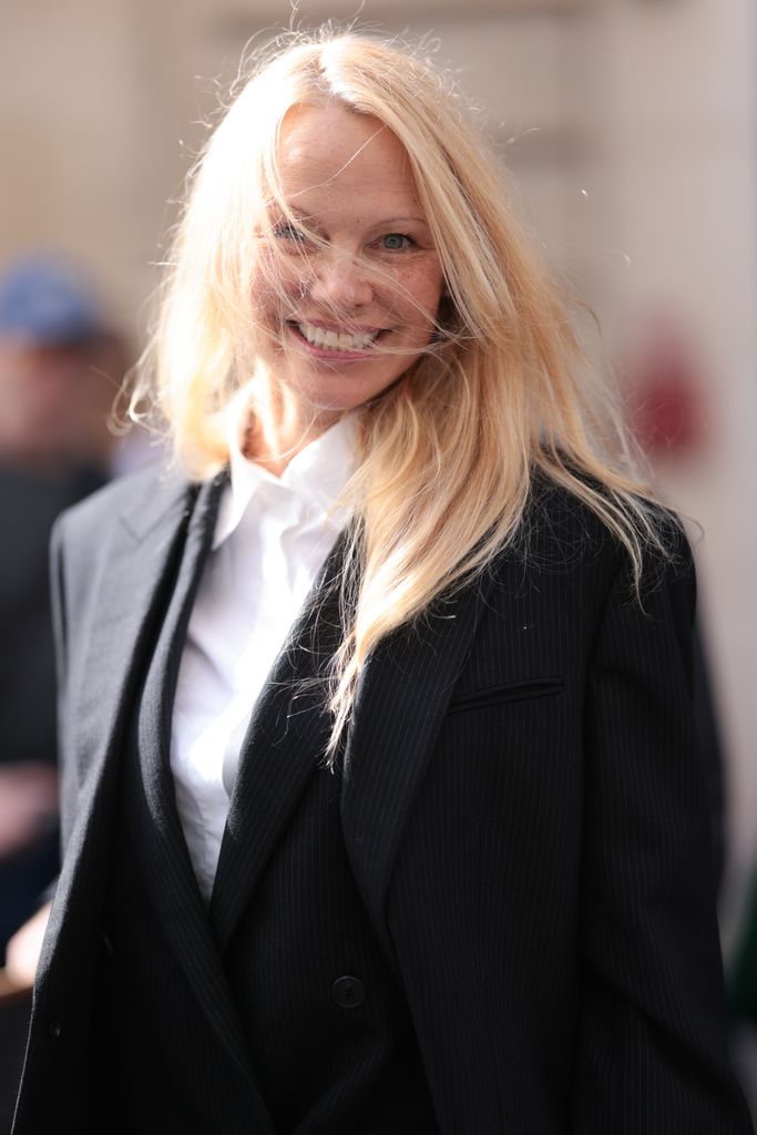  Pamela Anderson is seen outside The Row show wearing a white shirt and black blazer 