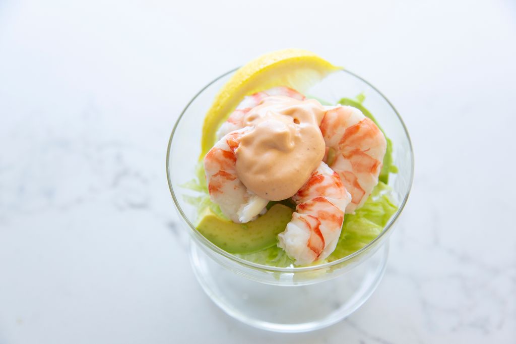 Prawn Cocktail, an old fashioned entree with iceberg lettuce, prawns, avocado and cocktail sauce.
