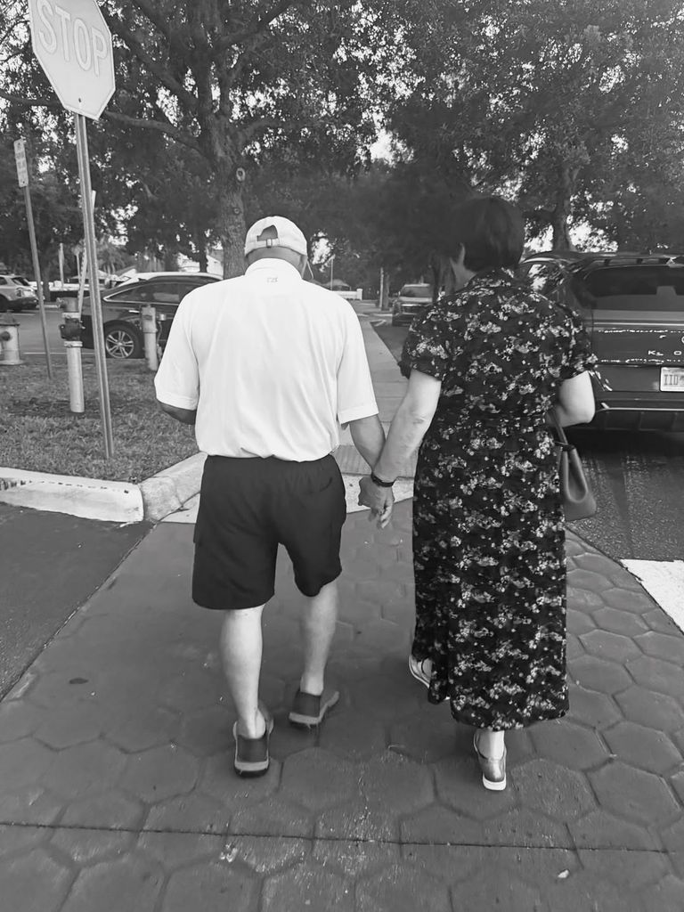 Dara Huang's parents walking away from the camera in a black and white photo