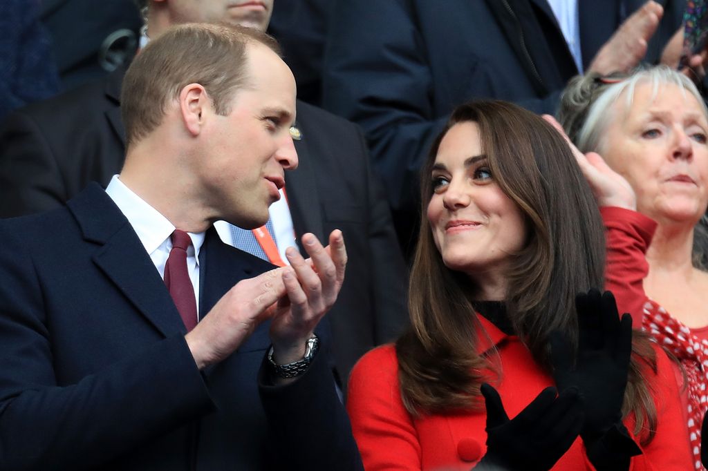 couple clapping at rugby match