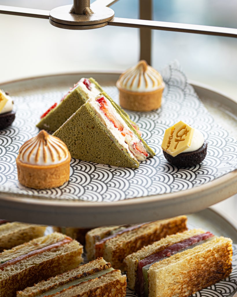 plate with selection of three desserts and sandwiches underneath