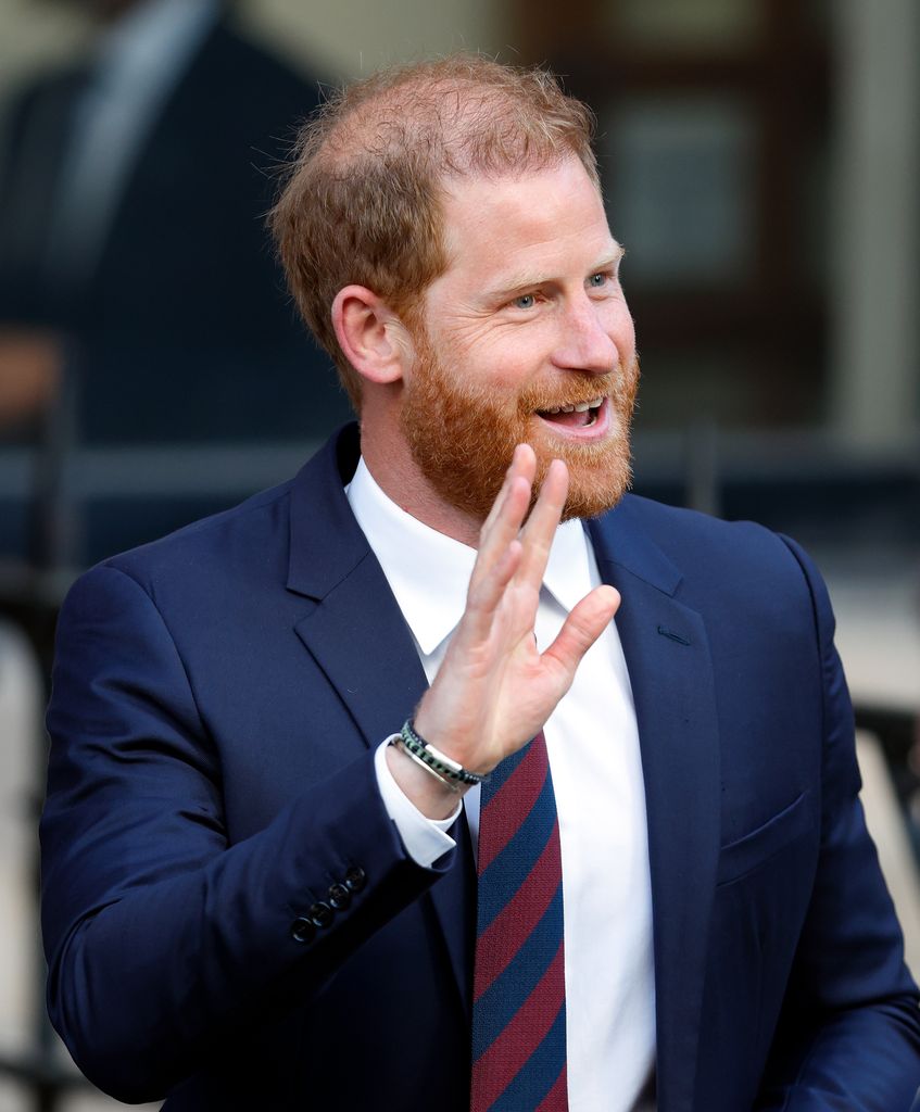 Prince Harry waving as he walks