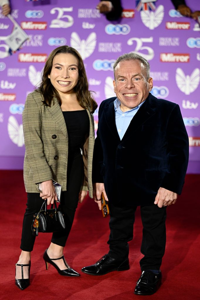 father and daughter smiling on red carpet 