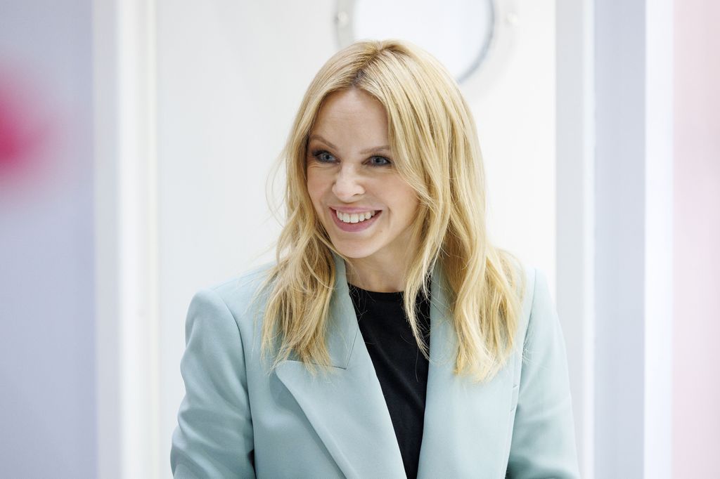 Kylie Minogue in blue jacket and black shirt
