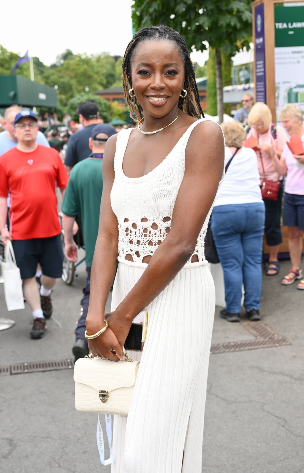AJ Odudu looked effortlessly chic in a whire crochet dress with an Aspinal of London bag.
