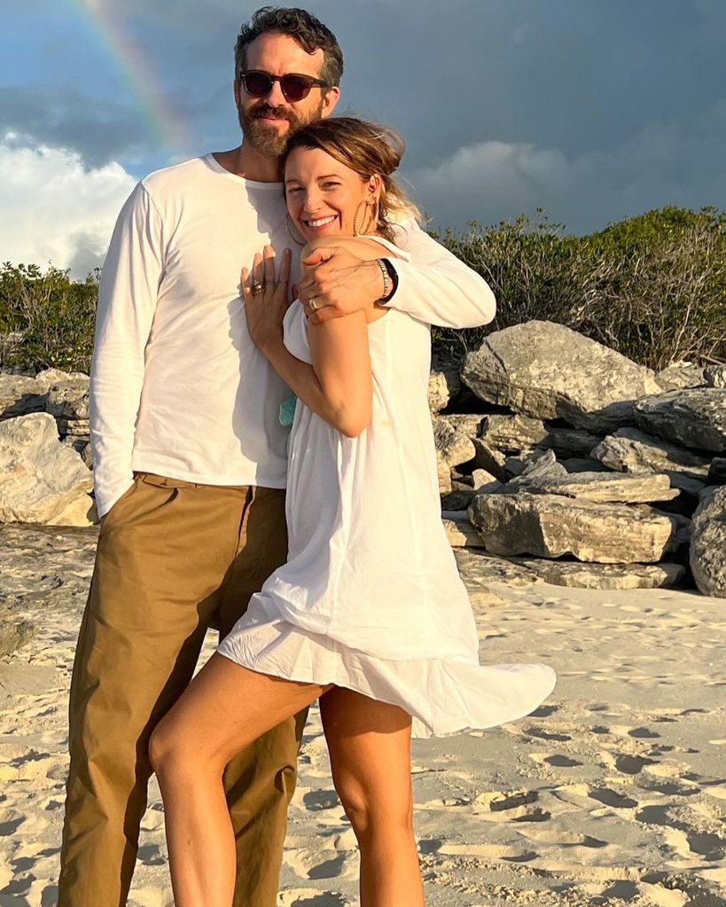 Ryan Reynolds and Blake Lively stand on the beach wrapped in each others arms